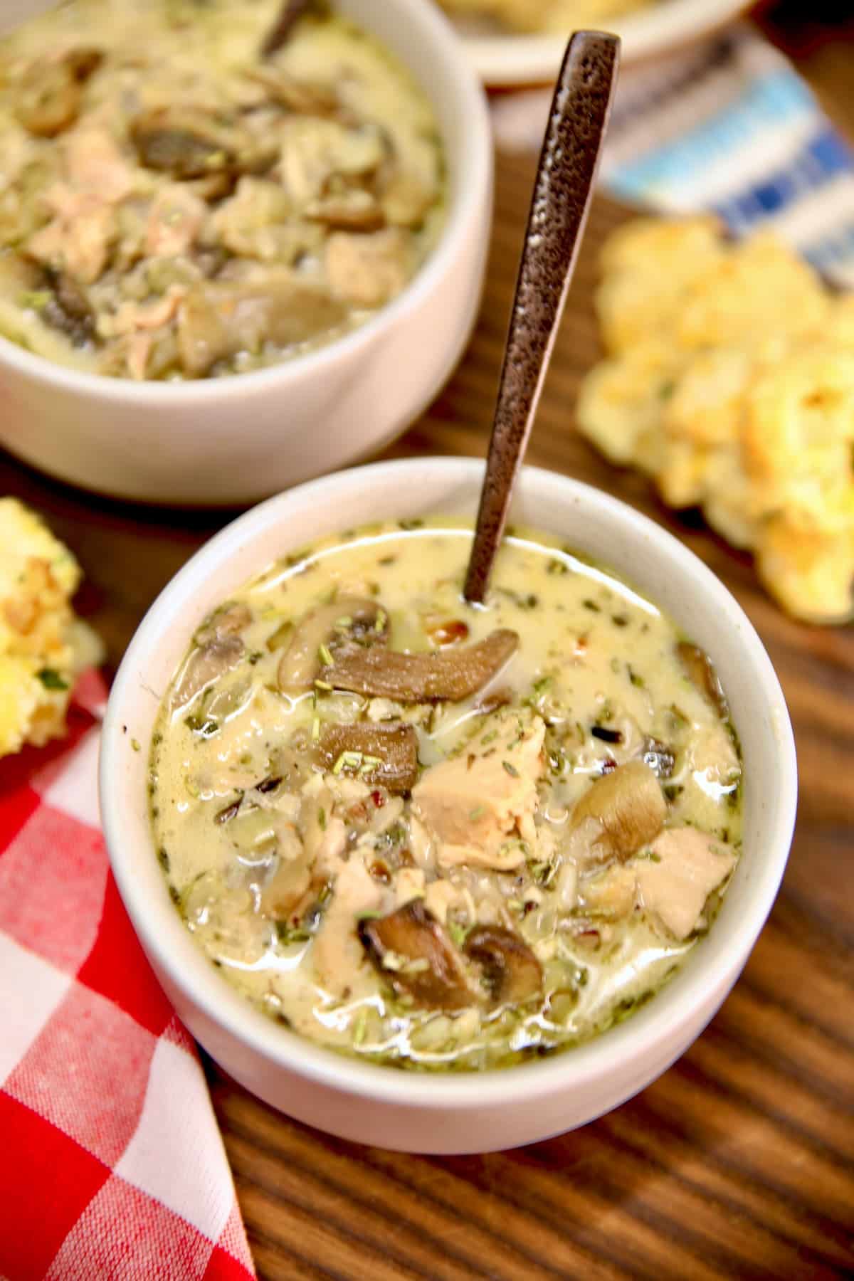 Bowl of chicken, mushroom and wild rice soup with a spoon.