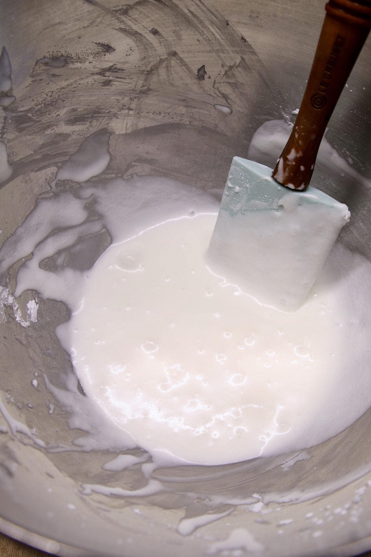 powdered sugar icing in a bowl with rubber spatula