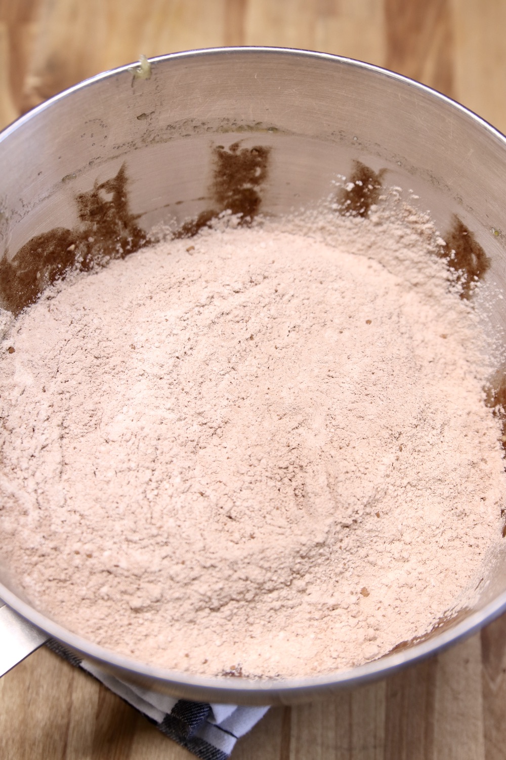 Dry ingredients added to banana bread batter in a mixing bowl