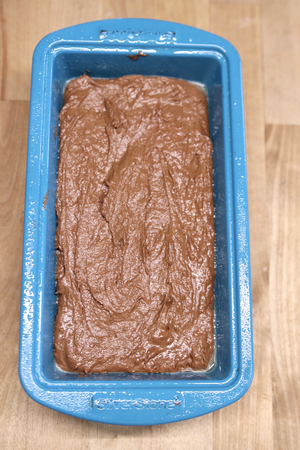 banana bread batter in a blue loaf pan