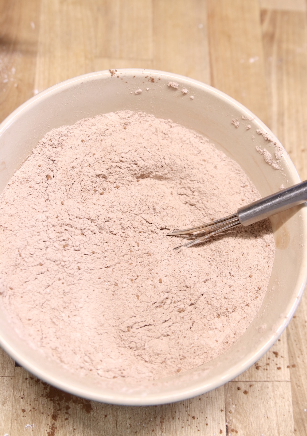 bowl of cocoa powder and flour mixed with a whisk
