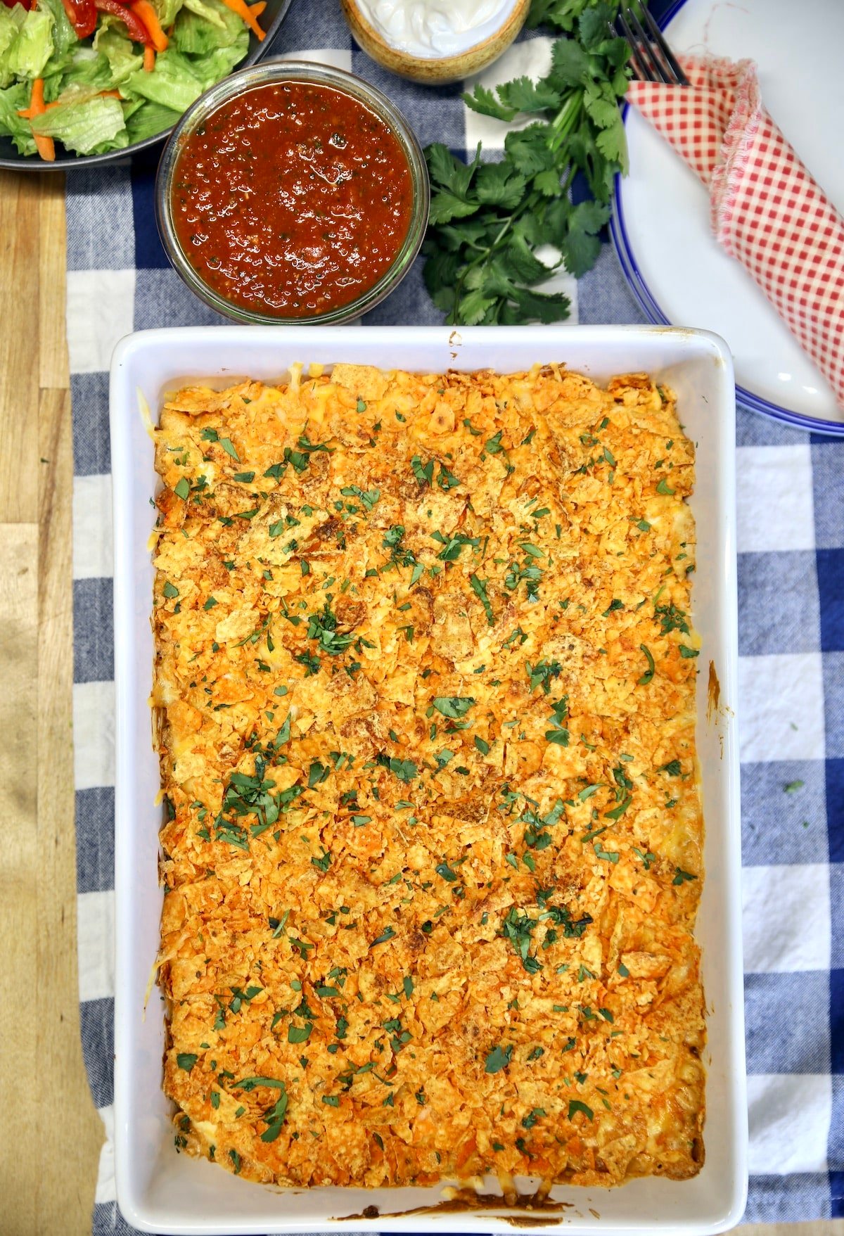 Pan of Doritos chicken casserole with salsa bowl.