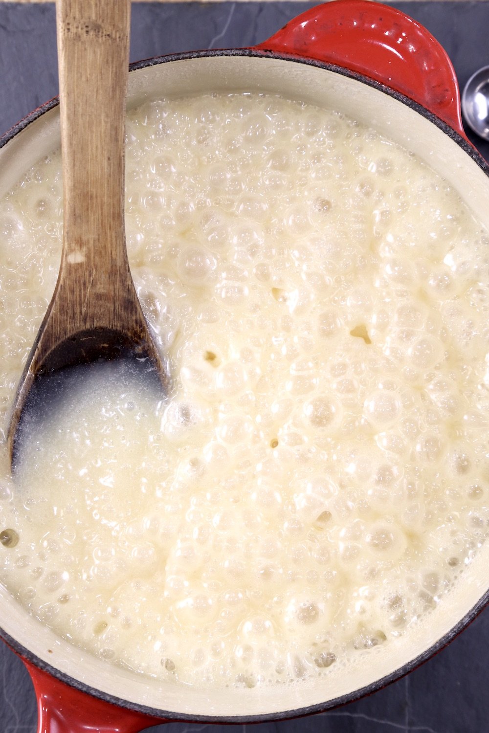 Making fudge in a pan with a wood spoon - mixture is boiling