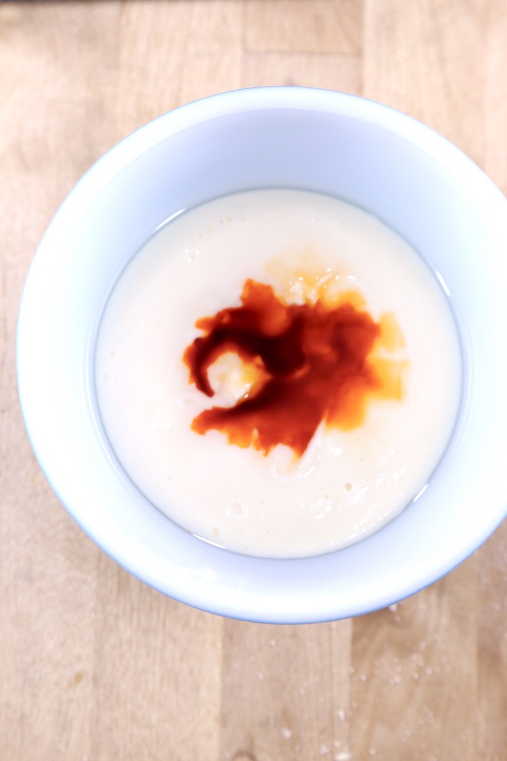 Small bowl of vanilla fudge with orange extract and orange food coloring