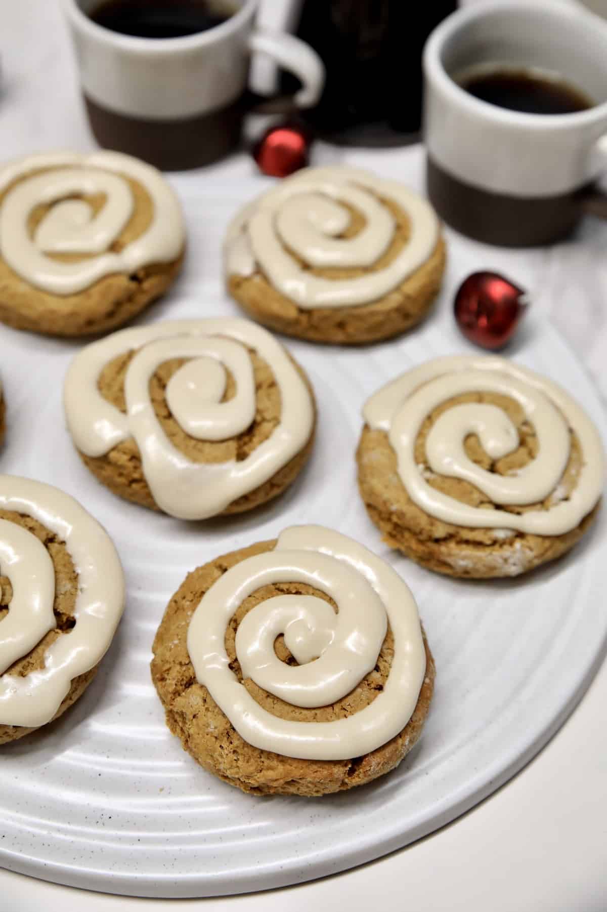 Gingerbread scones on a platter with cups of coffee.
