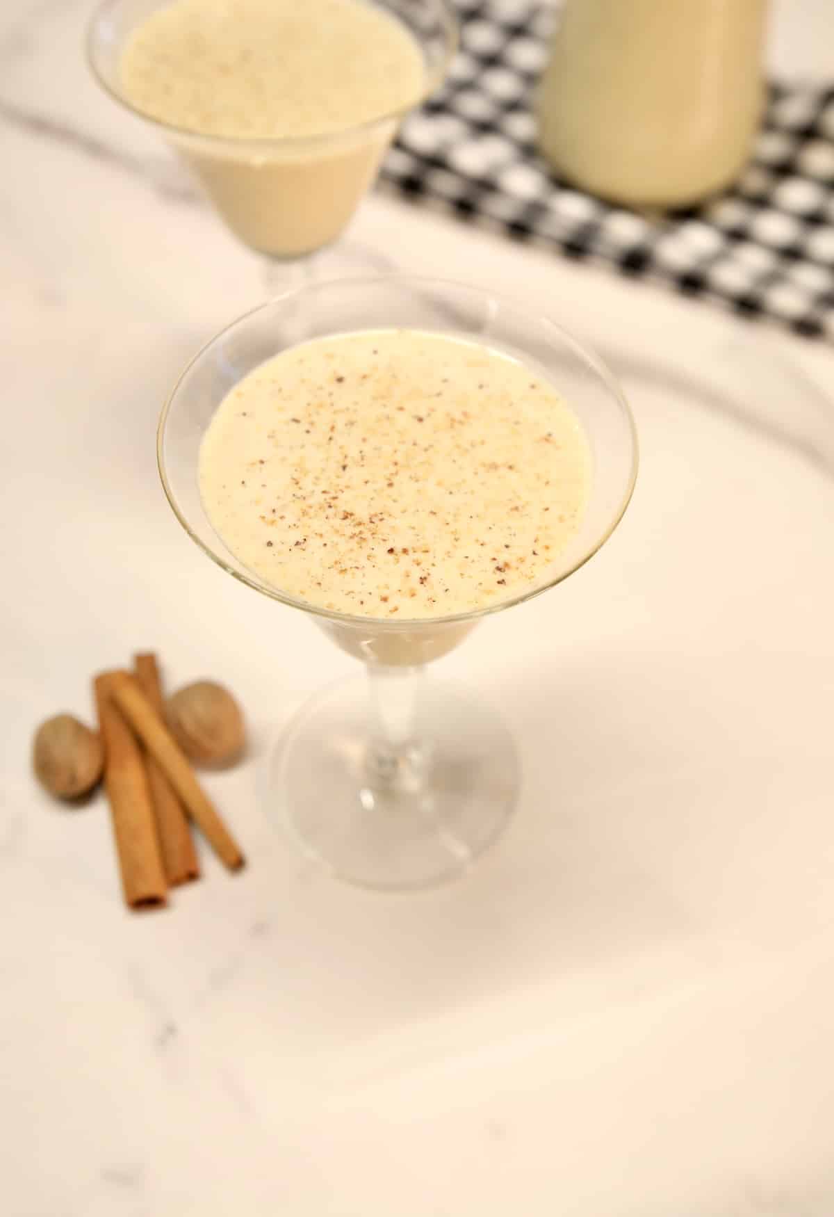 2 coupe glasses with eggnog.