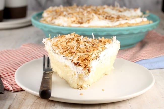 Coconut Cream Pie slice topped with whipped cream and toasted coconut