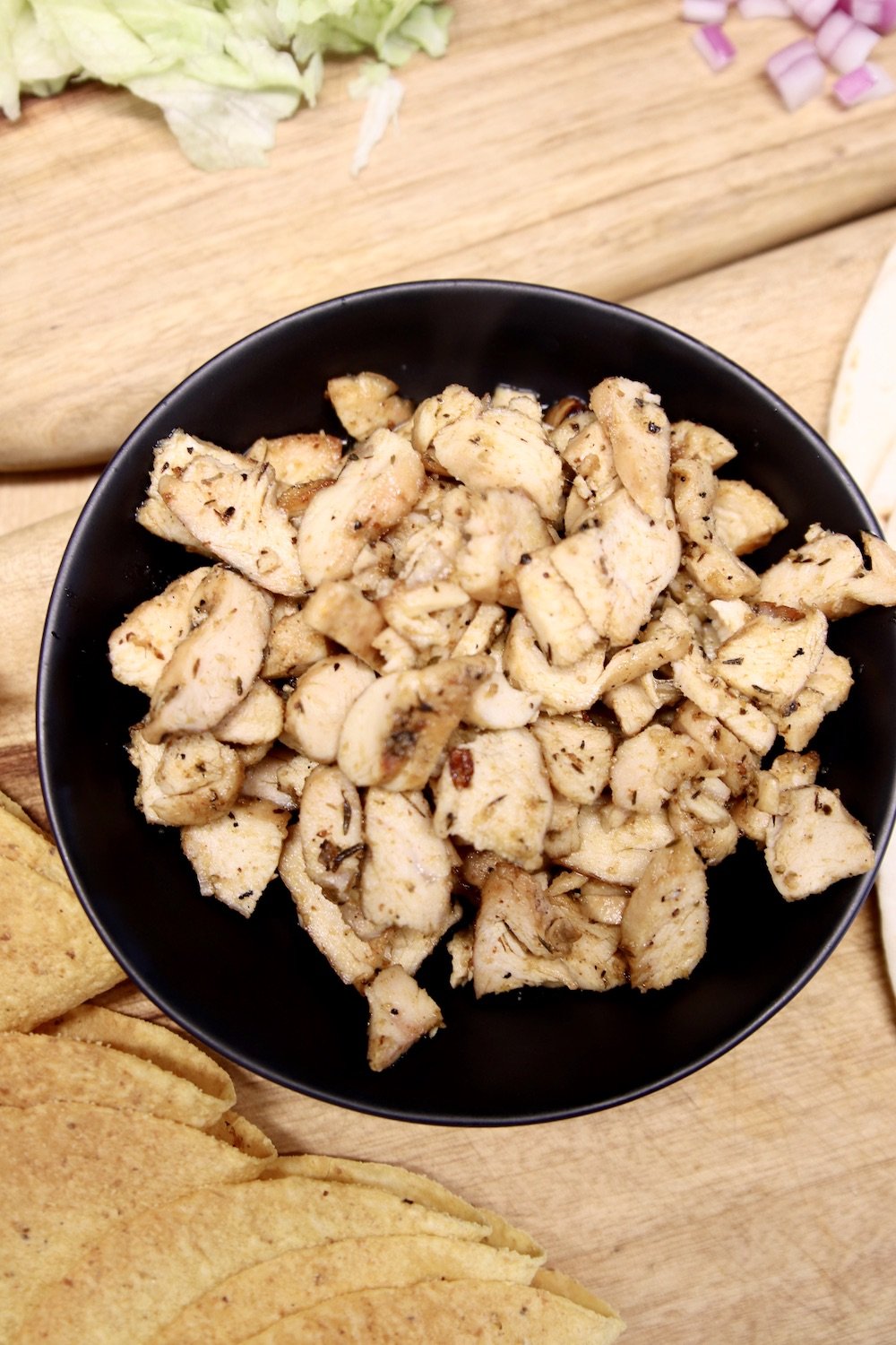 black bowl of chopped grilled chicken