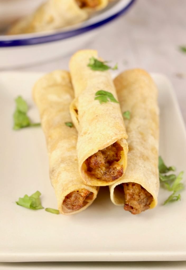 3 beef taquitos on a white plate