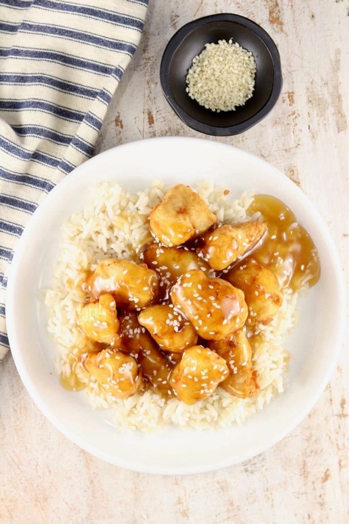 Striped napkin, plate of sesame chicken and rice