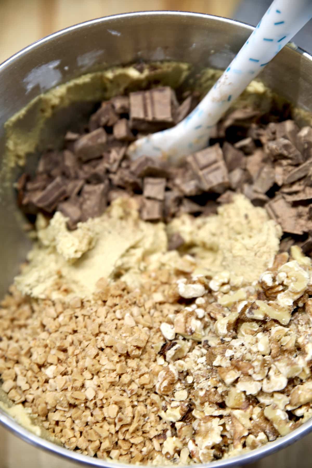 Bowl of cookie dough with chocolate, walnuts and toffee bits.