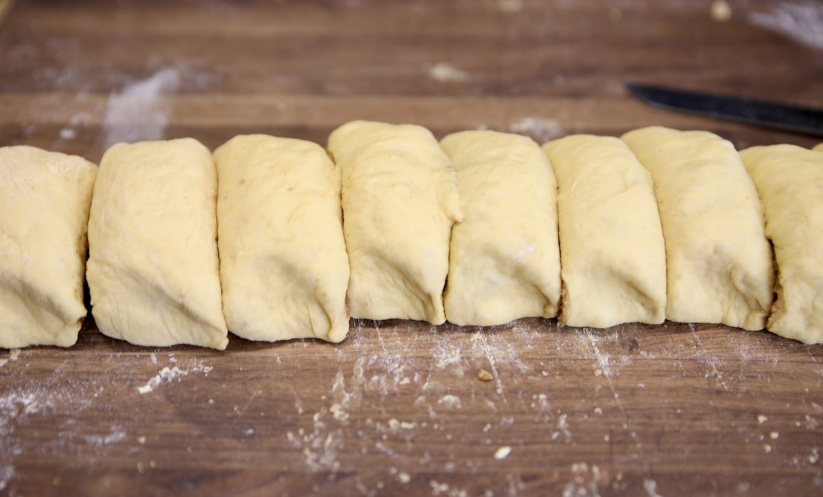 Sliced cinnamon rolls on a board.
