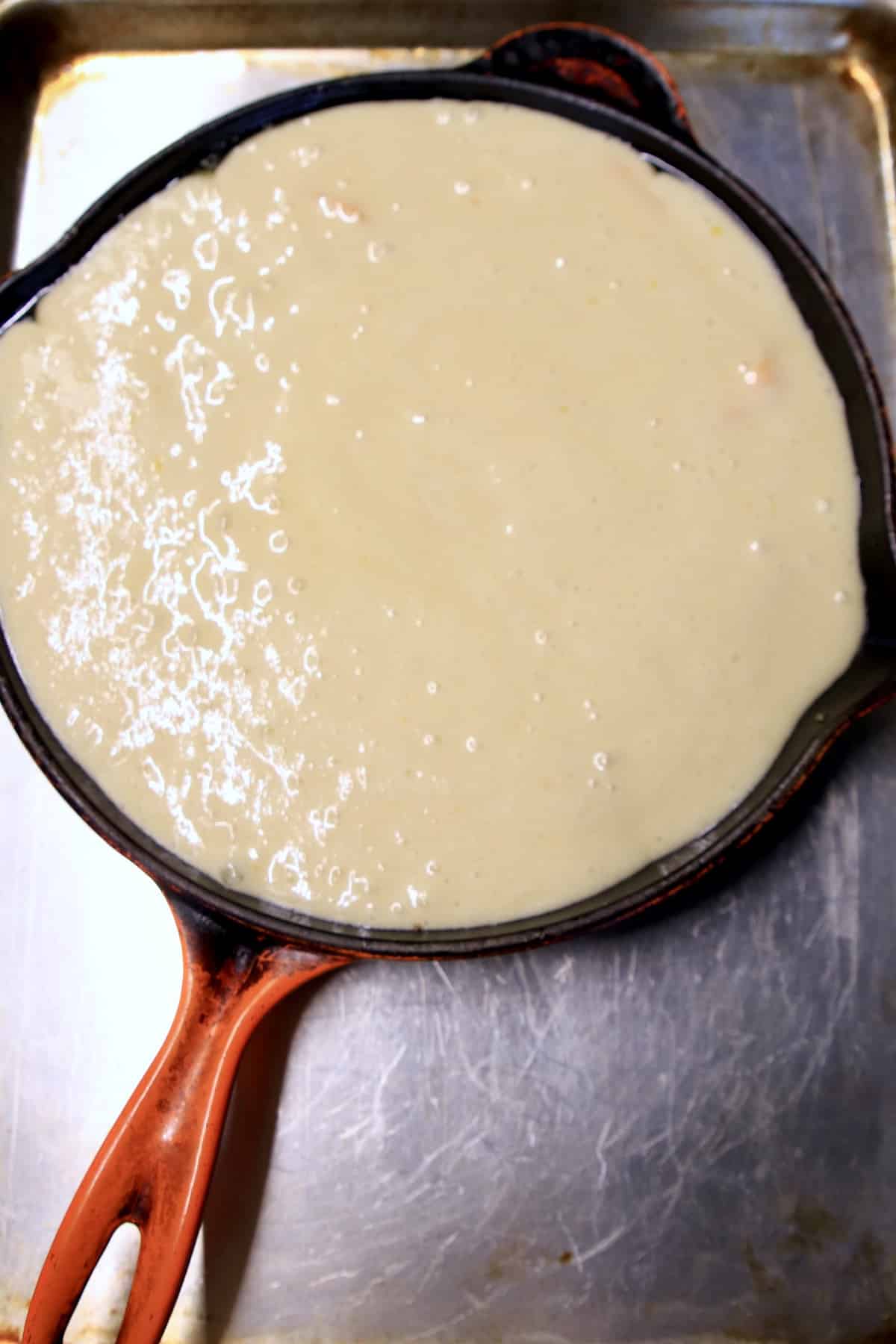 Skillet with upside down cake ready to bake on a baking sheet.