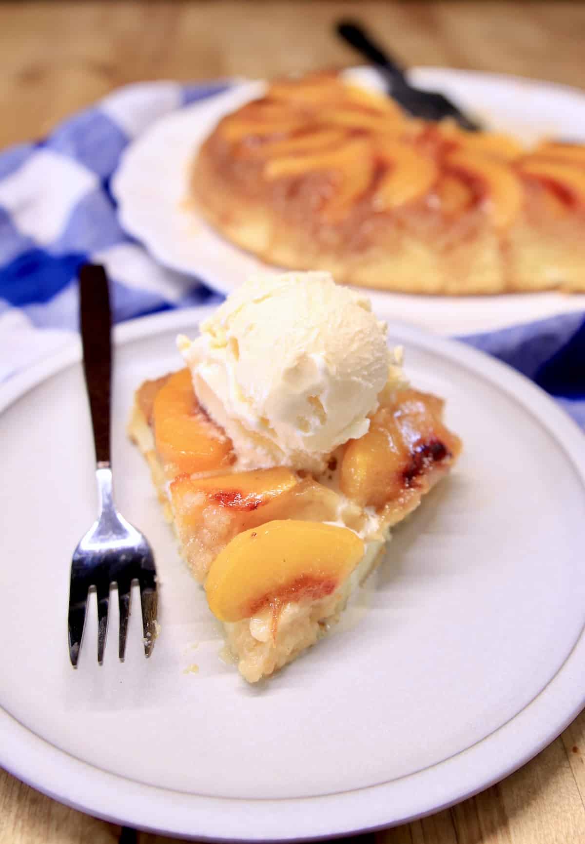 Slice of peach upside down cake with vanilla ice cream.