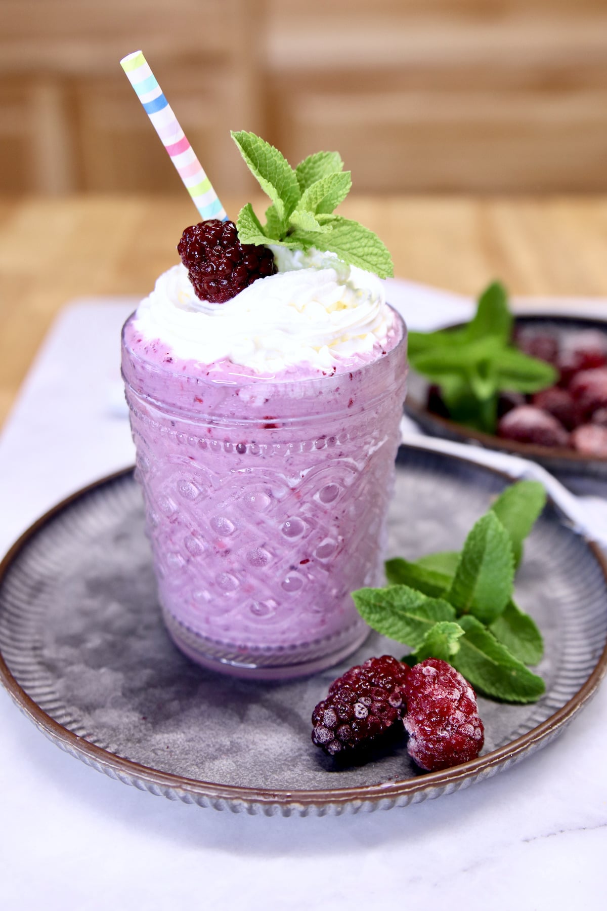 Blackberry Milkshake in a glass with whipped cream. 