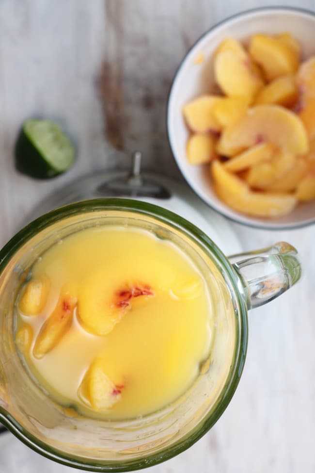 Blender with ingredients for frozen peach margaritas