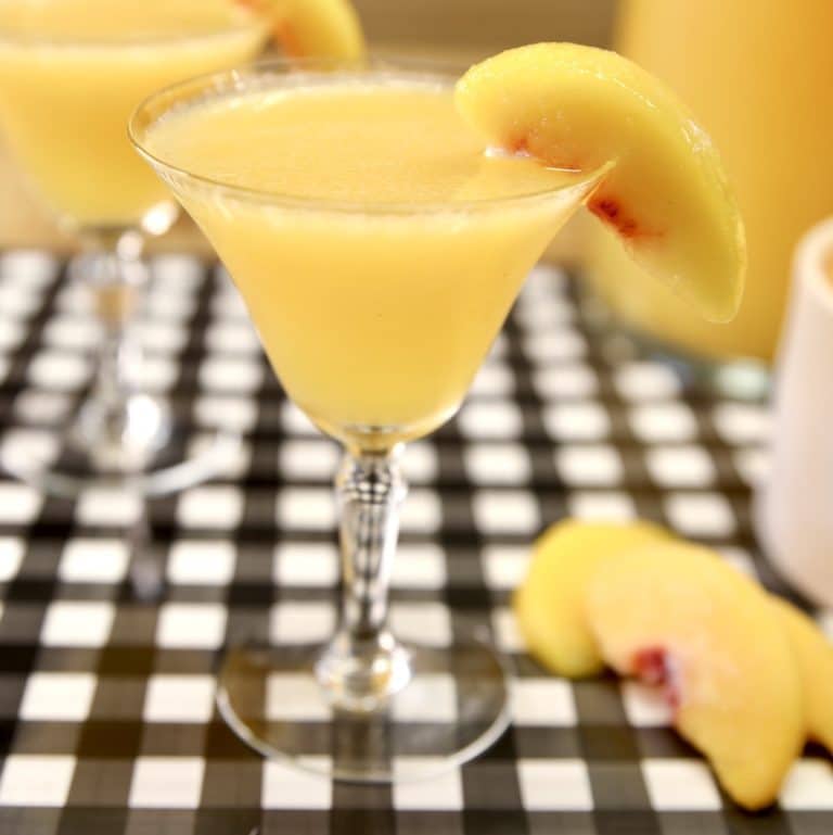 Peach moscato punch in a glass with peach slice.