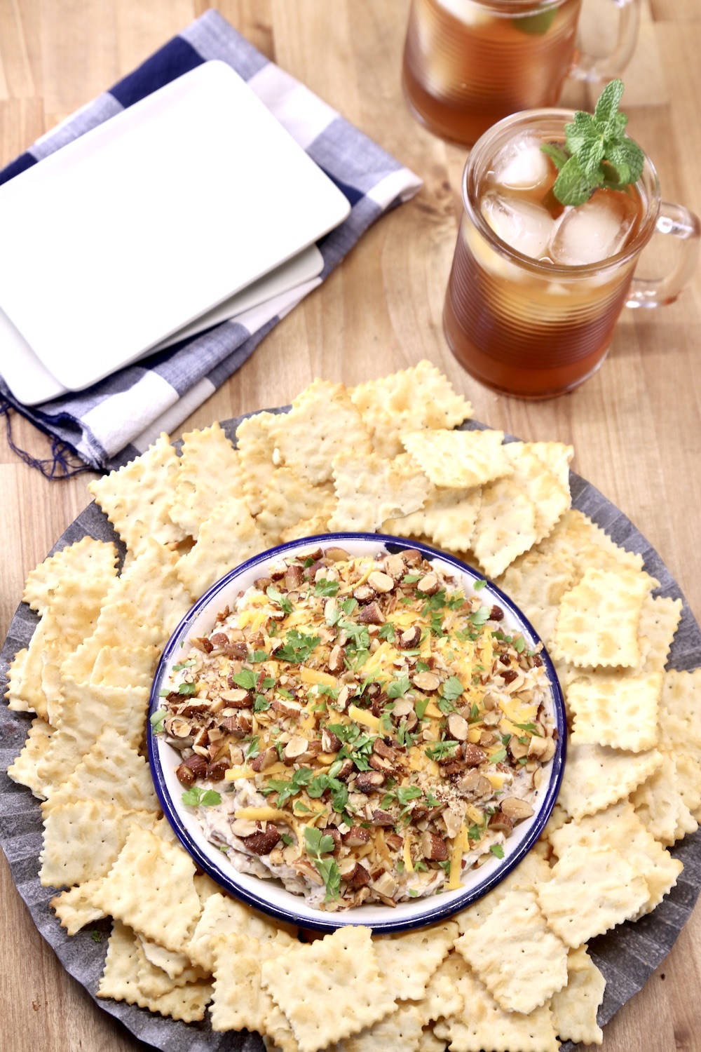party dip on a platter with chips, 2 glasses iced tea, small appetizer plates