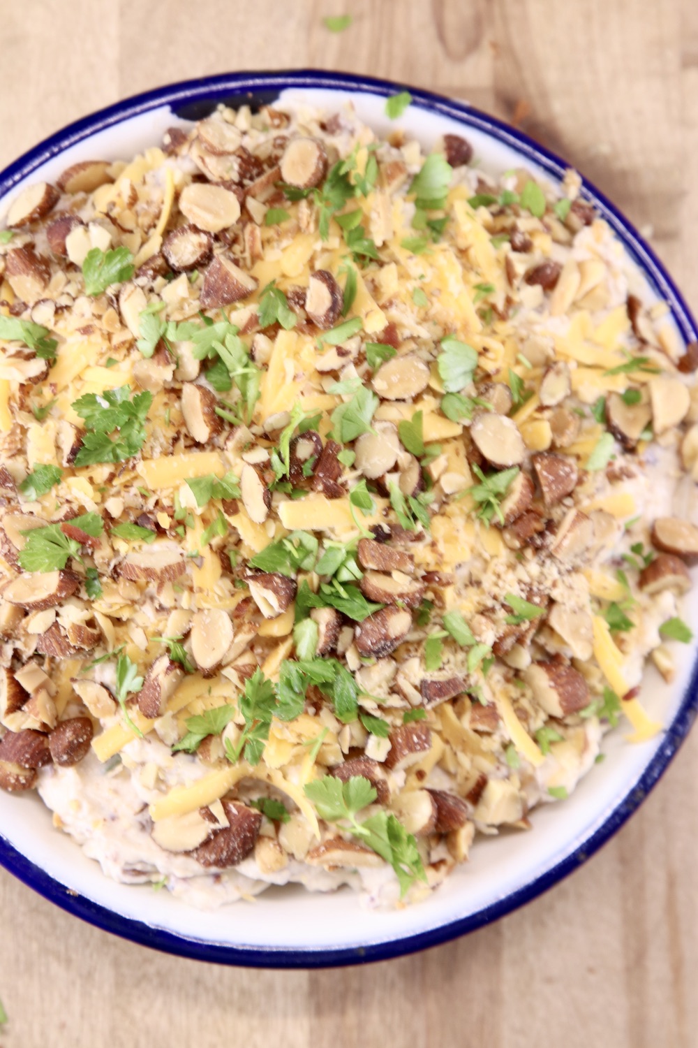 party dip with bacon and cheese in a bowl with blue rim