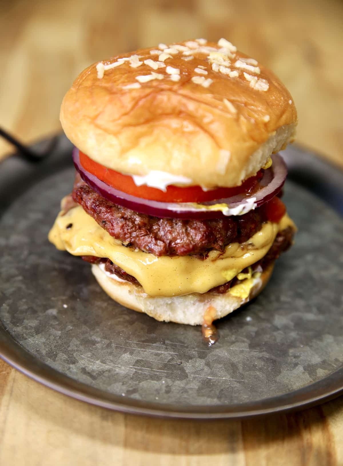 Double cheeseburger on a tin plate.
