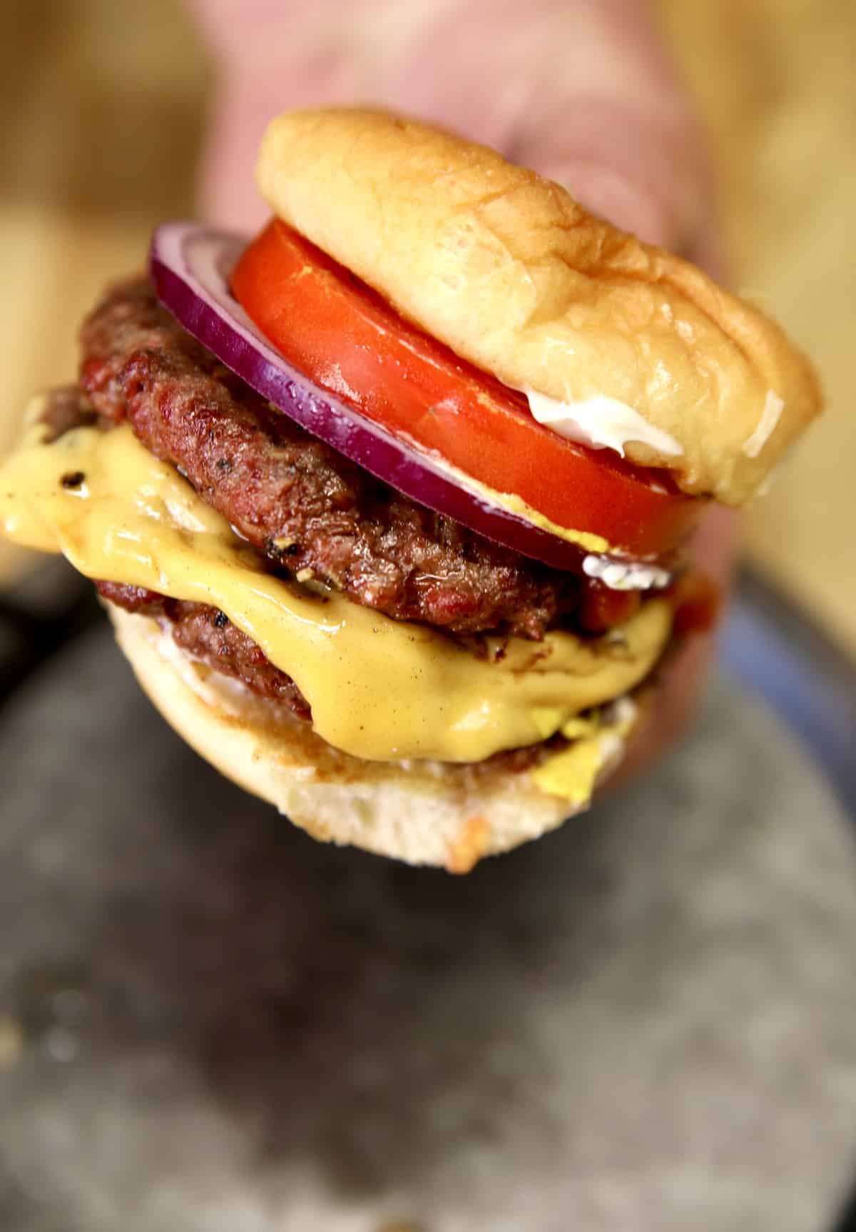Double Cheeseburger held in hand.