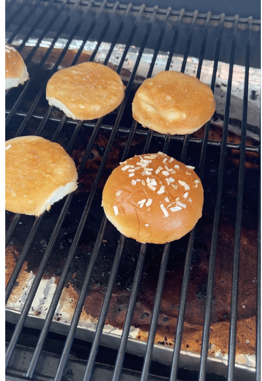 Burger buns toasting on grill.