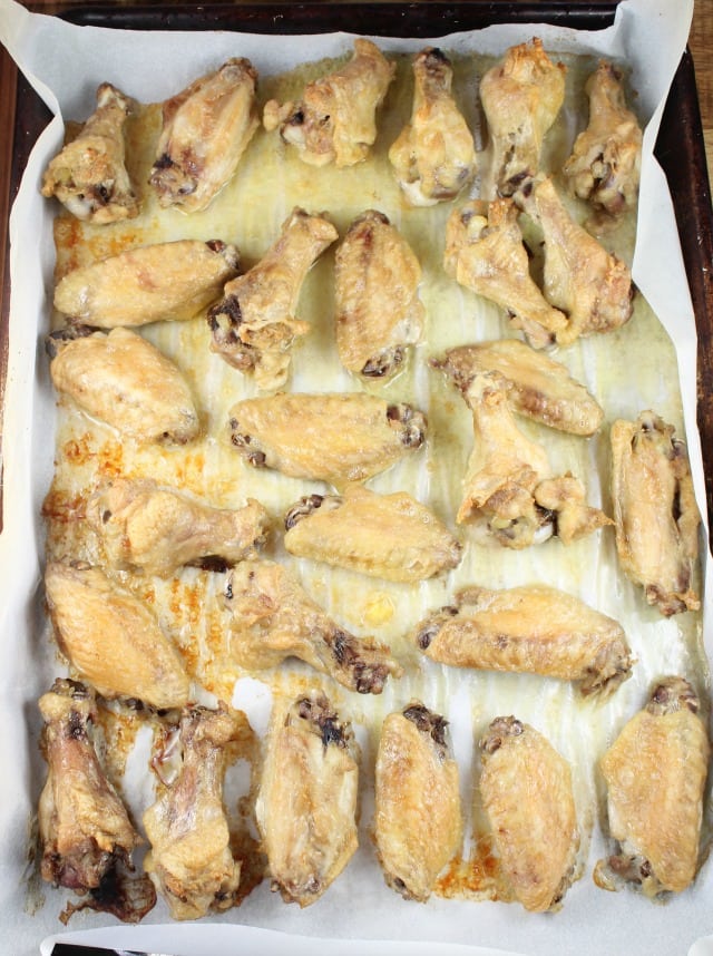 Parchment Lined Baking Sheet with Crispy Baked Asian Chicken Wings from MissintheKitchen.com