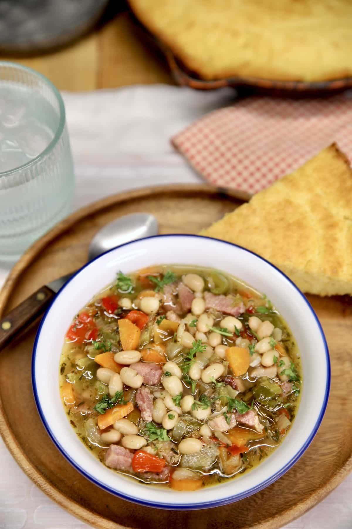 Ham and Bean Soup served in a bowl with cornbread on the side.