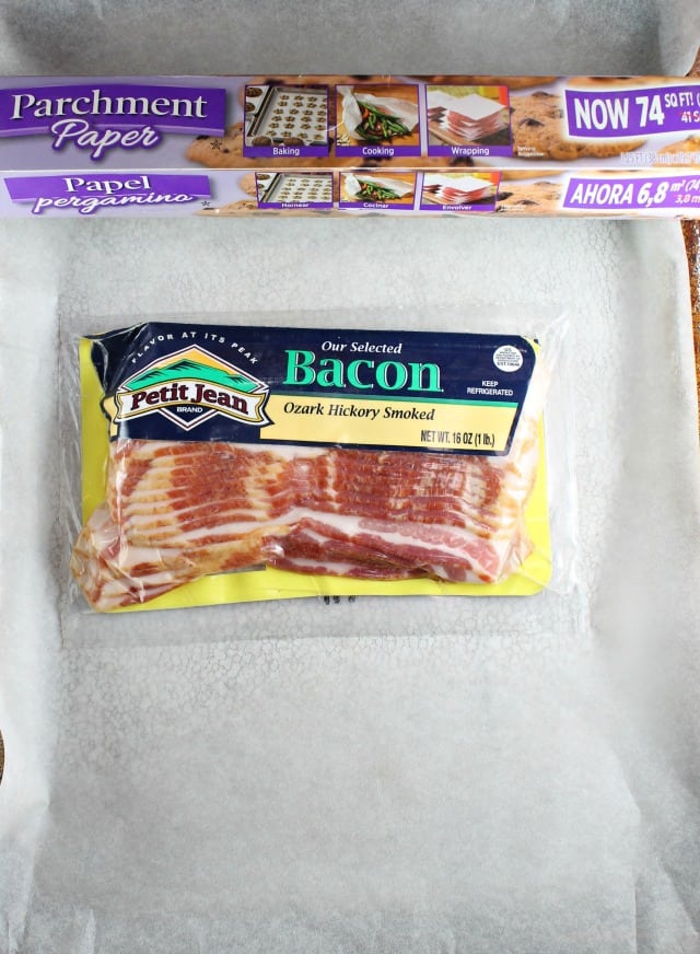 Package of Petit Jean Bacon on a parchment lined baking sheet with parchment paper box