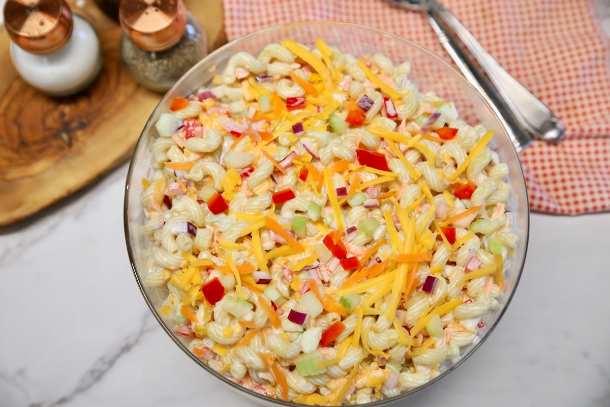 Bowl of macaroni salad with red napkin, spoon.