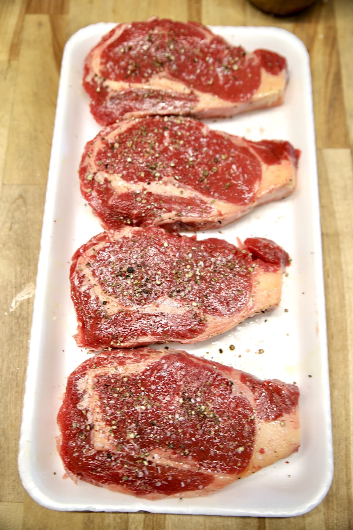 4 ribeye steaks seasoned with salt and pepper. 