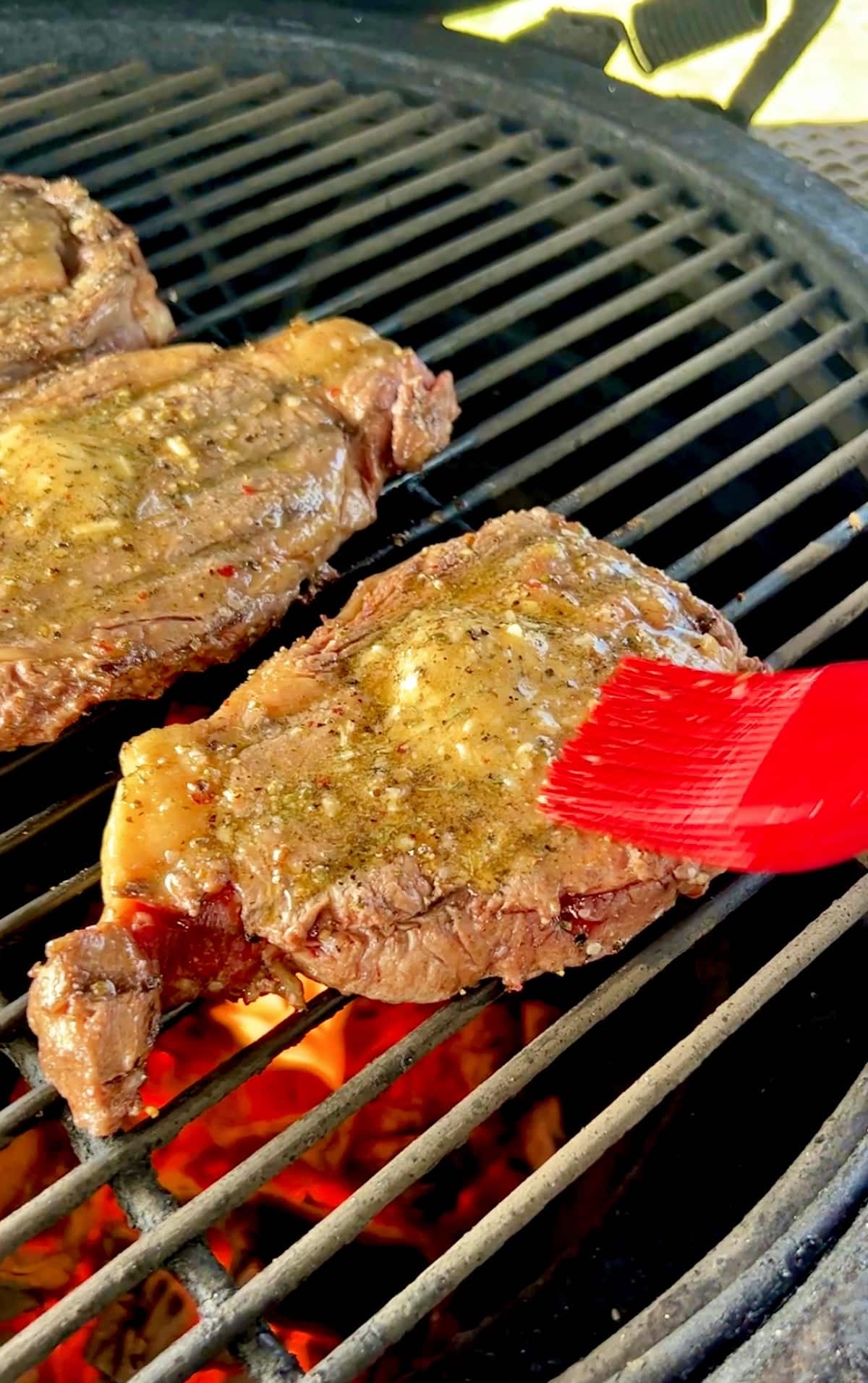 Spreading butter on grilled steak.