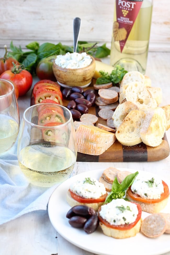 Fresh Heirloom Tomato and Herbed Ricotta Bruschetta and charcuterie board with sausage, cheese and muscadine wine