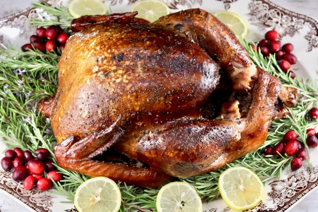 Platter with smoked turkey, sliced lemons, cranberries and fresh rosemary
