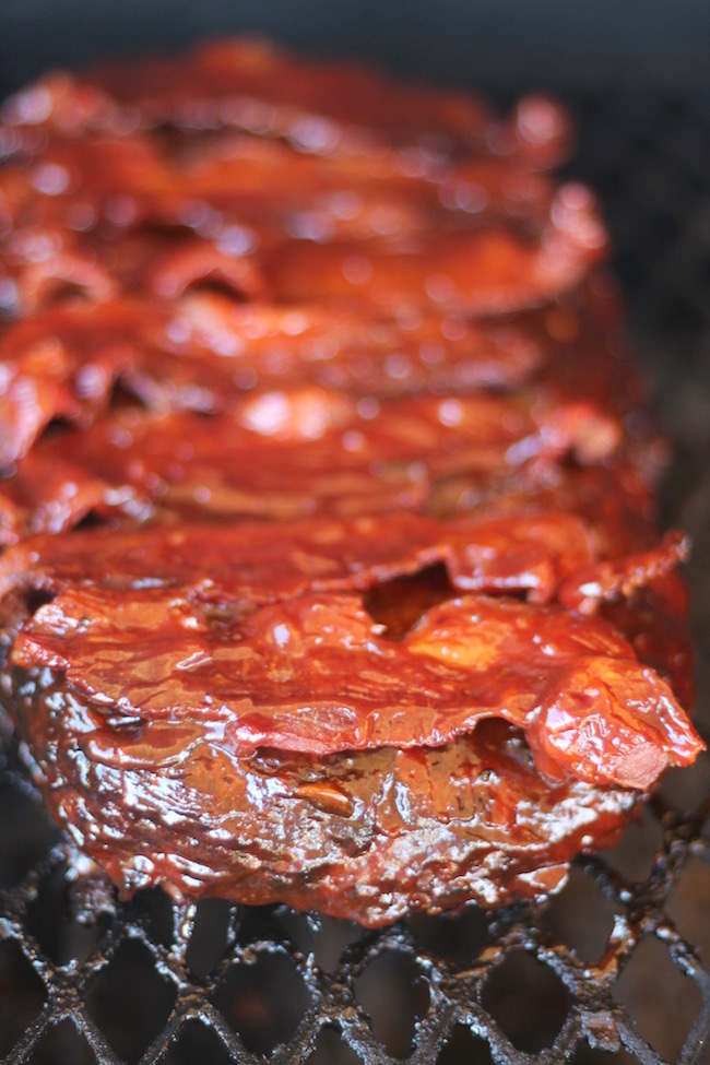 Classic Meatloaf topped with barbecue sauce and bacon on the grill for the best smoked meatloaf