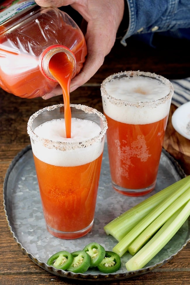 Pouring V8 Juice into glass for Red Beer Cocktail