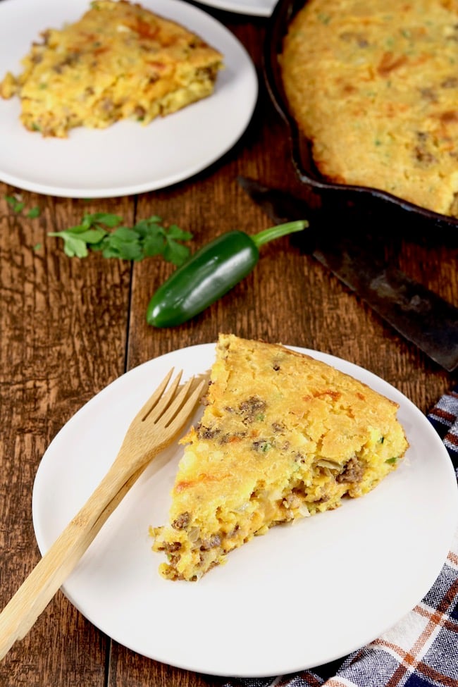 Mexican Cornbread slice on a white plate with a bamboo fork