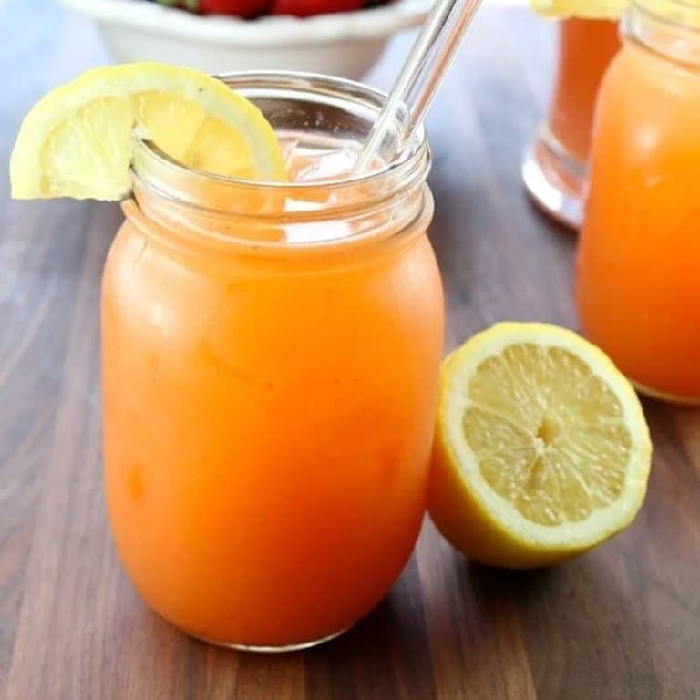 Berry punch in a glass with lemon garnish.