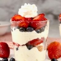 Cheesecake Parfaits in a glass with whipped cream on top