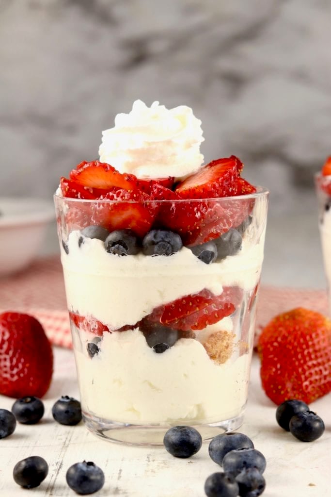 Berry Cheesecake Parfaits in a glass with whipped cream on top