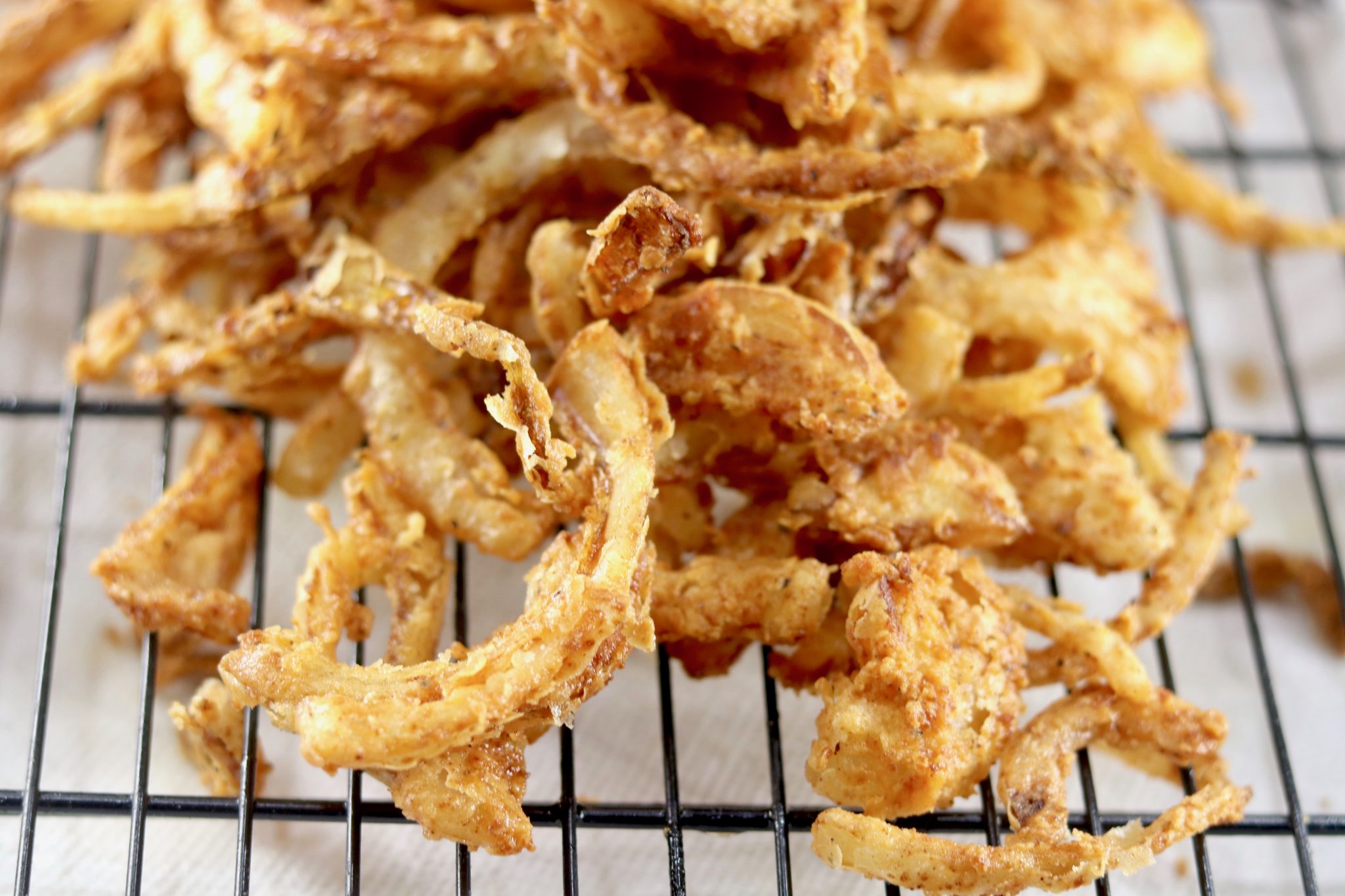 Fried onions on a wire rack. Easy Onion Strings