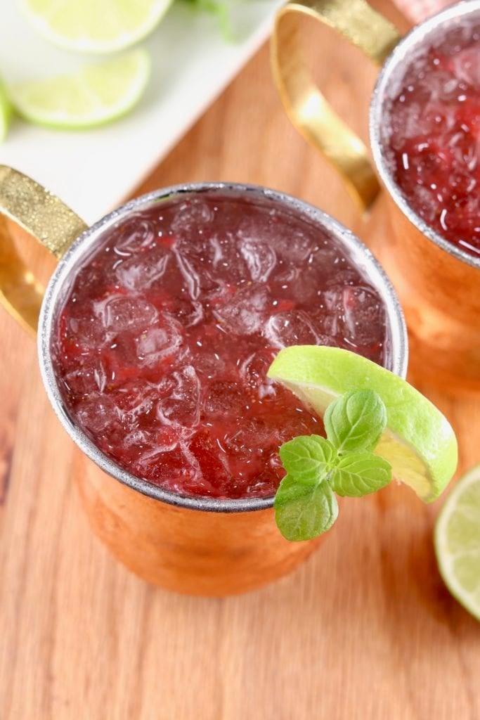 Strawberry Mango Moscow Mule garnished with lime and mint in a copper mug