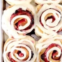 Pan of blackberry filled sweet rolls with cream cheese swirled icing