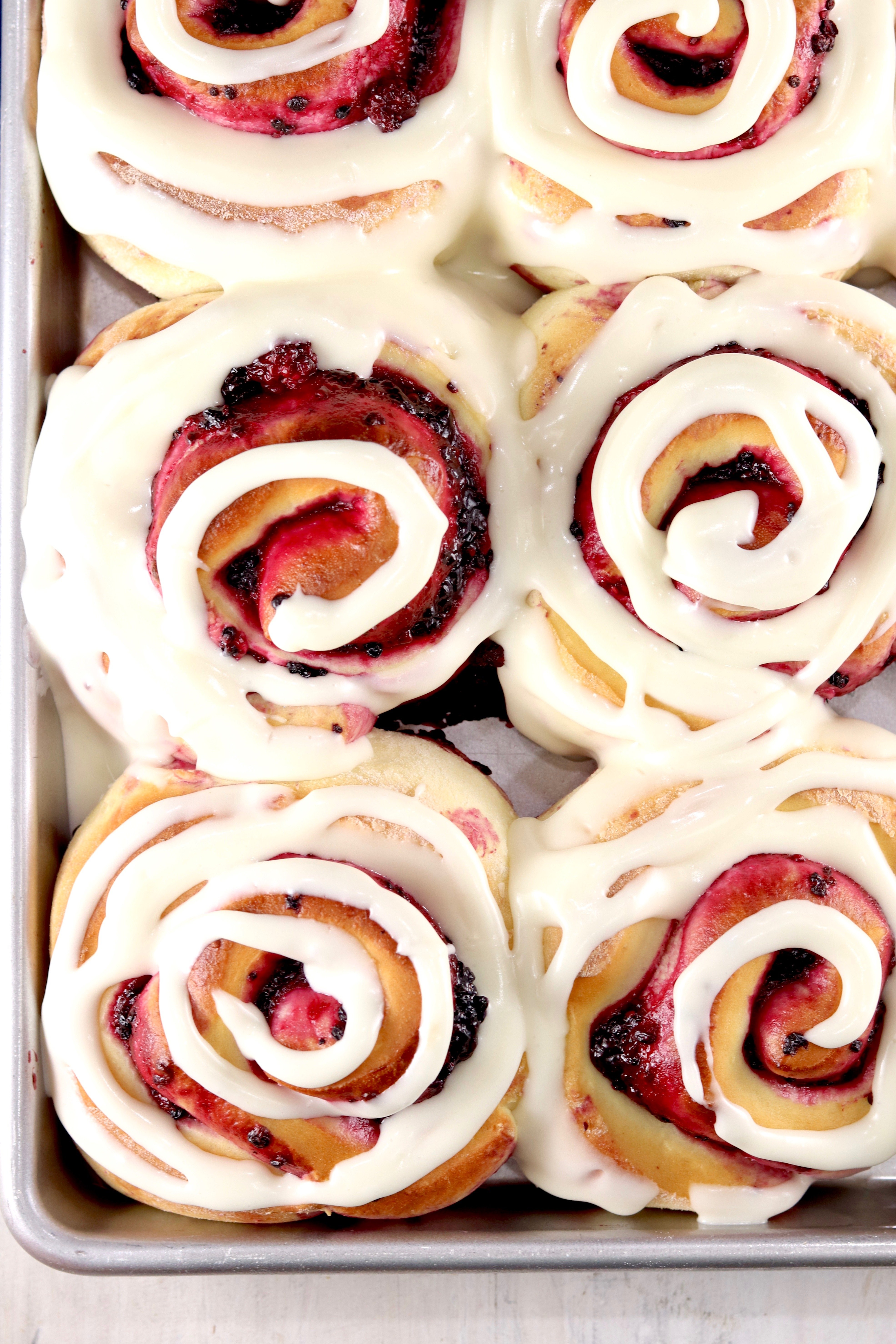 Pan of blackberry filled sweet rolls with cream cheese swirled icing