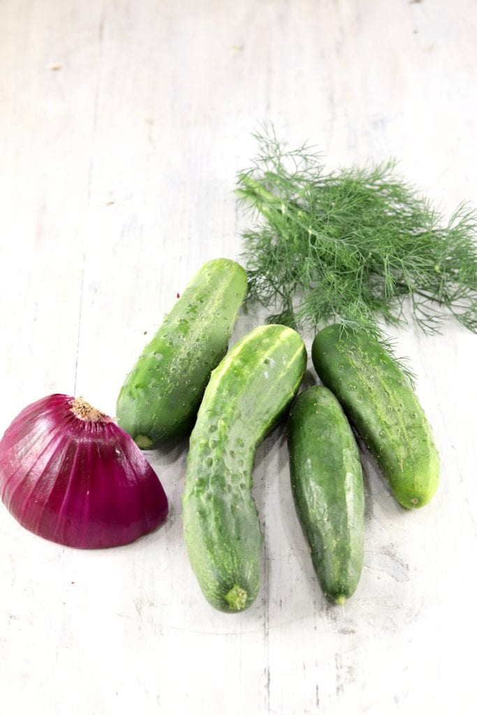 Red Onion, Fresh Cucumbers, fresh dill on a white board
