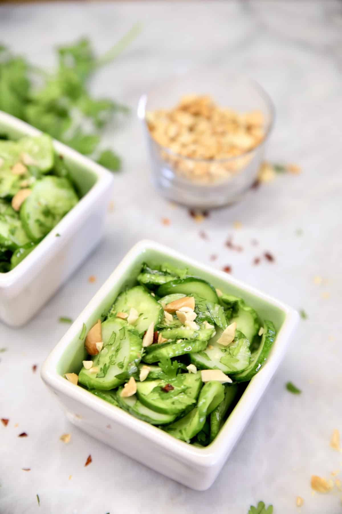 2 bowls of cucumber salad, small bowl of chopped peanuts.