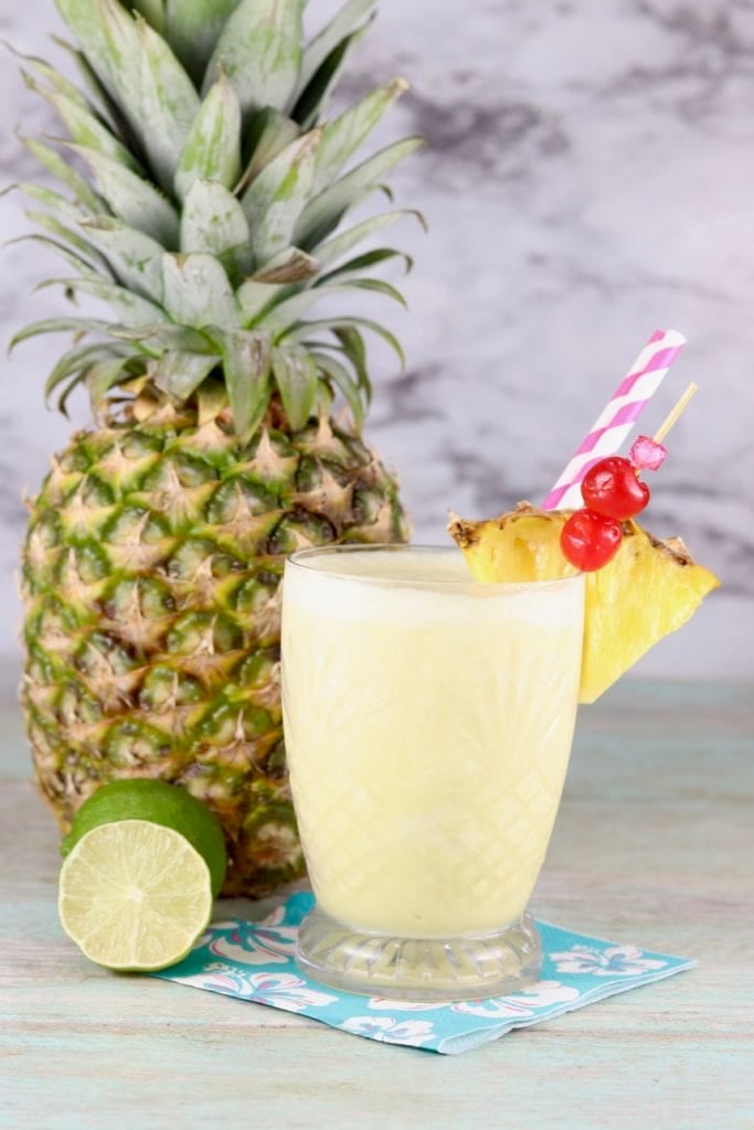 Frozen pineapple drink with a fresh pineapple in background