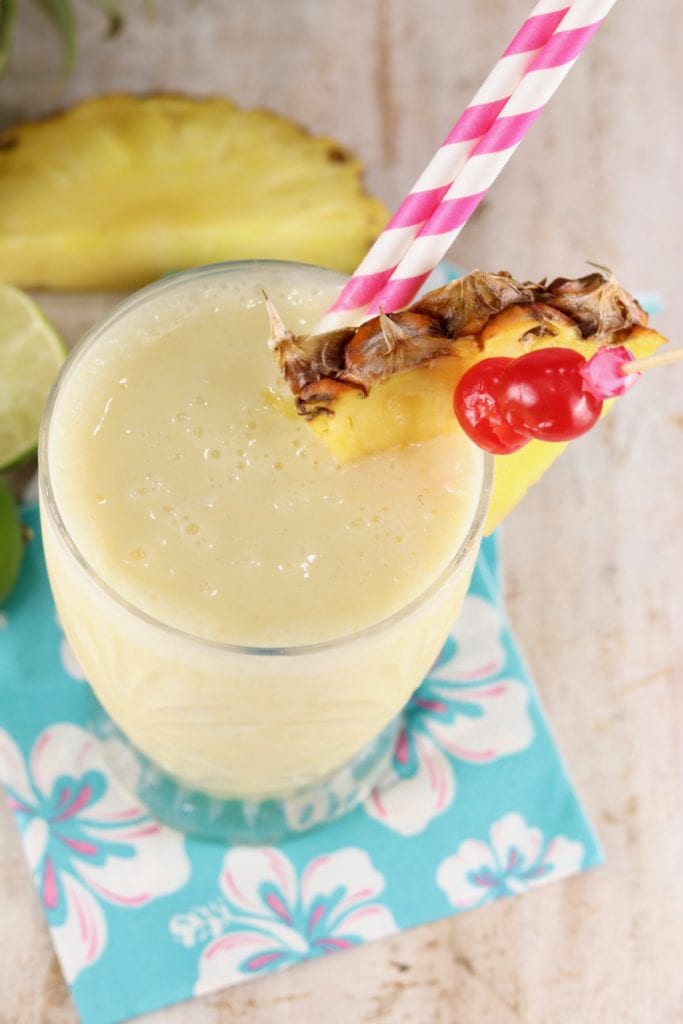 overhead shot of non alcoholic pina colada with fresh pineapple and cherries
