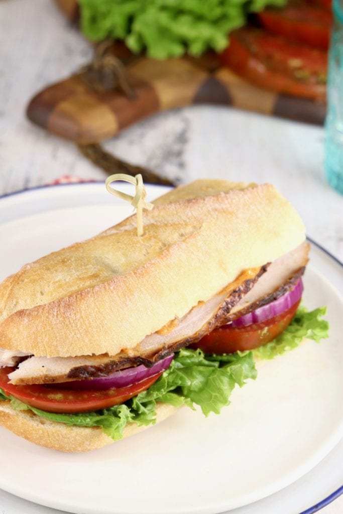 Baguette sandwich with smoked turkey, tomato, lettuce and red onion