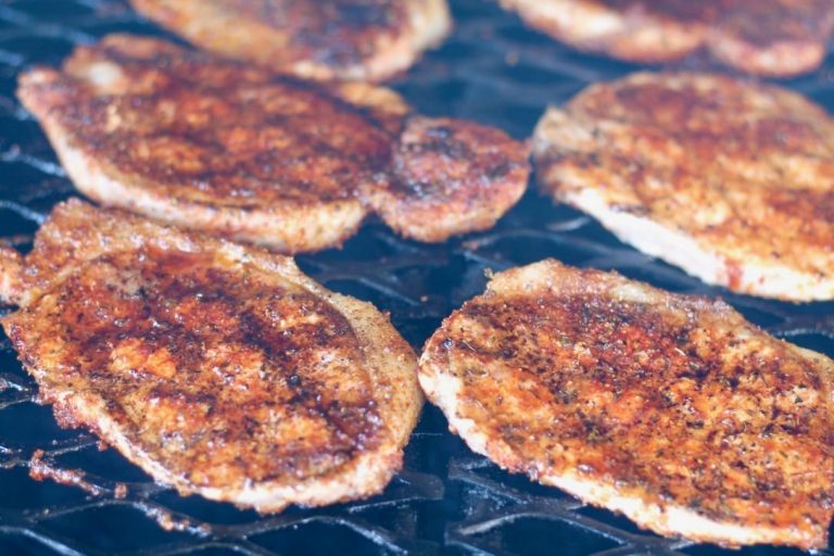 Boneless pork chops on grill with Cajun spices